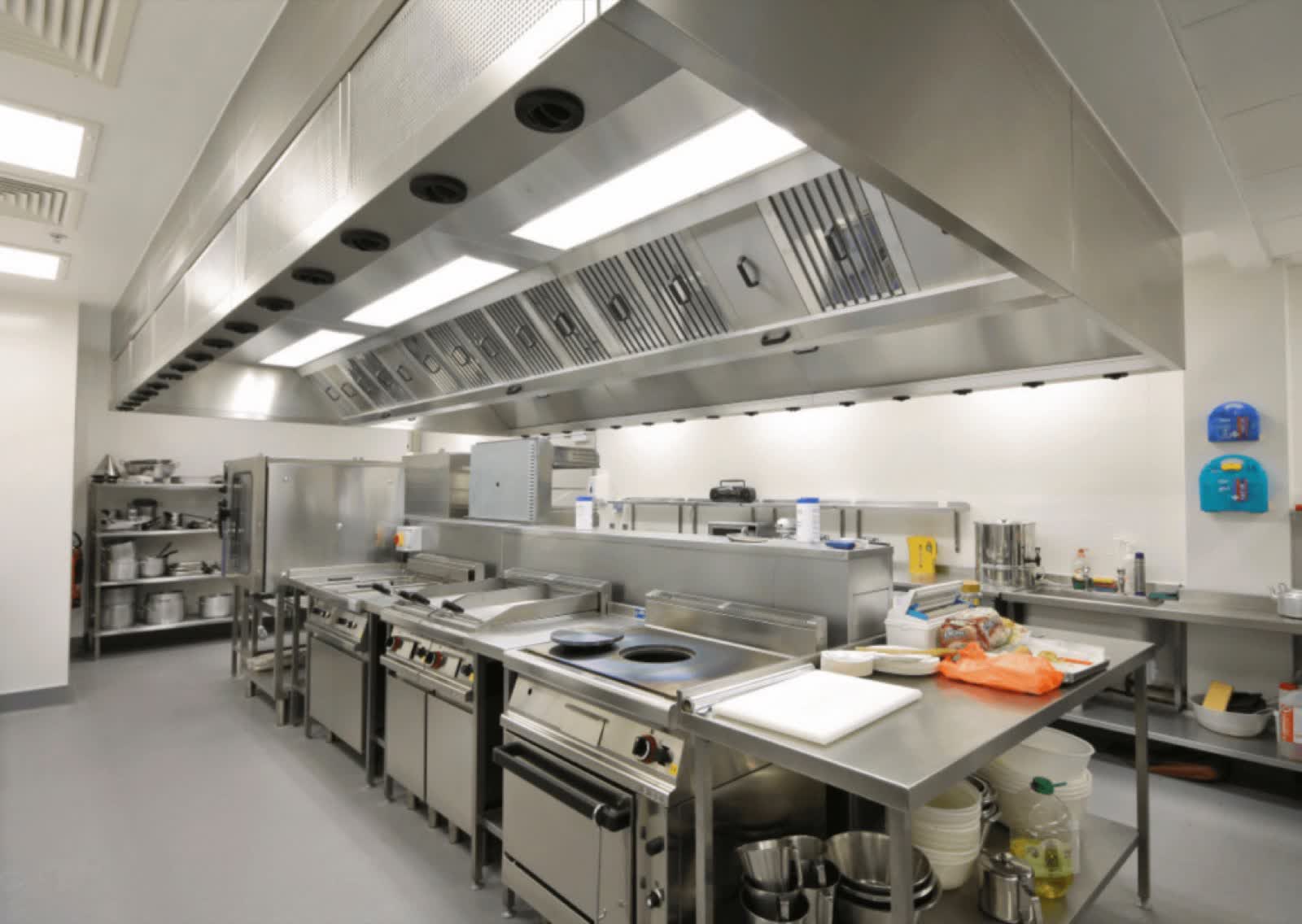 Commercial kitchen line with hood and equipment